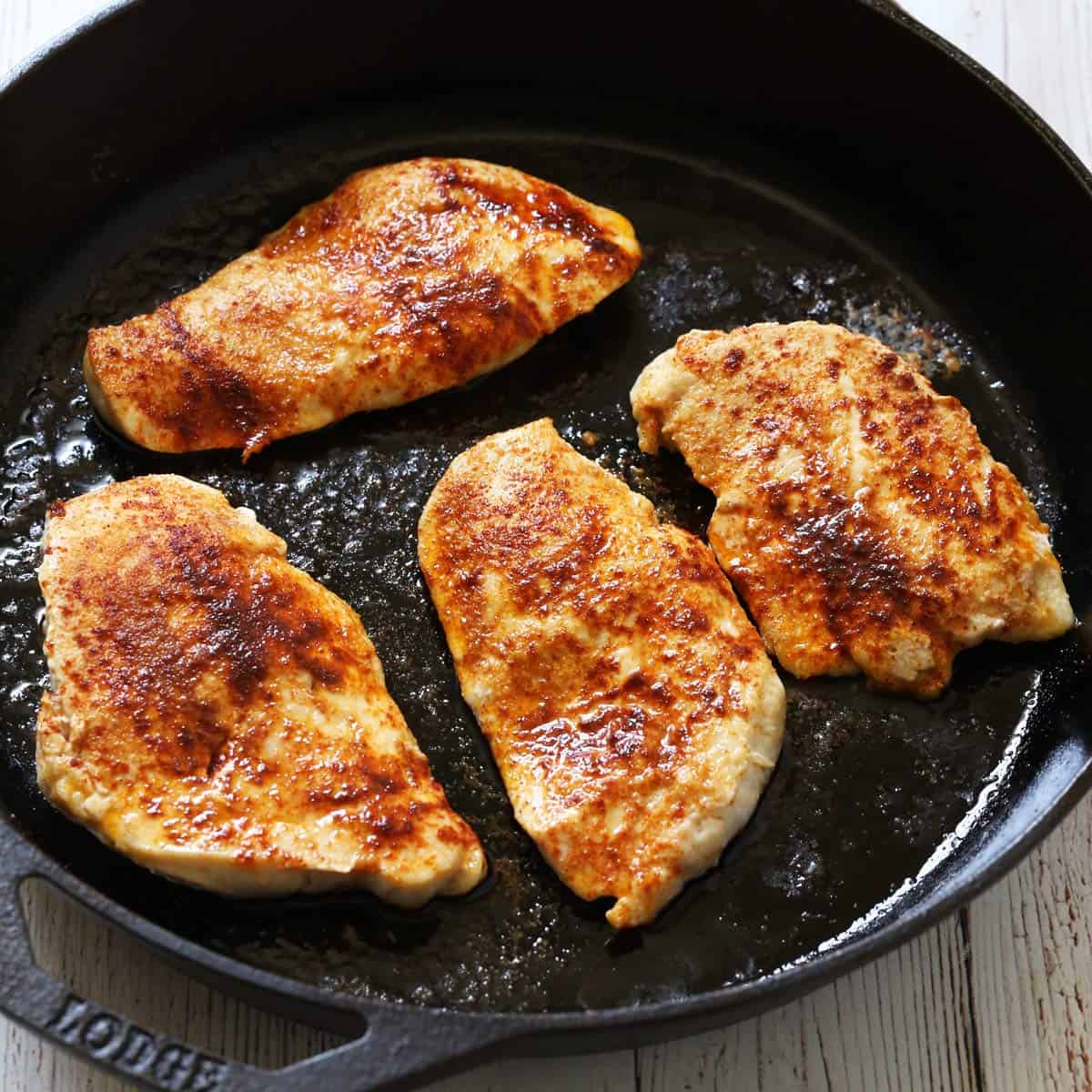 Broiling chicken in a cast-iron skillet.