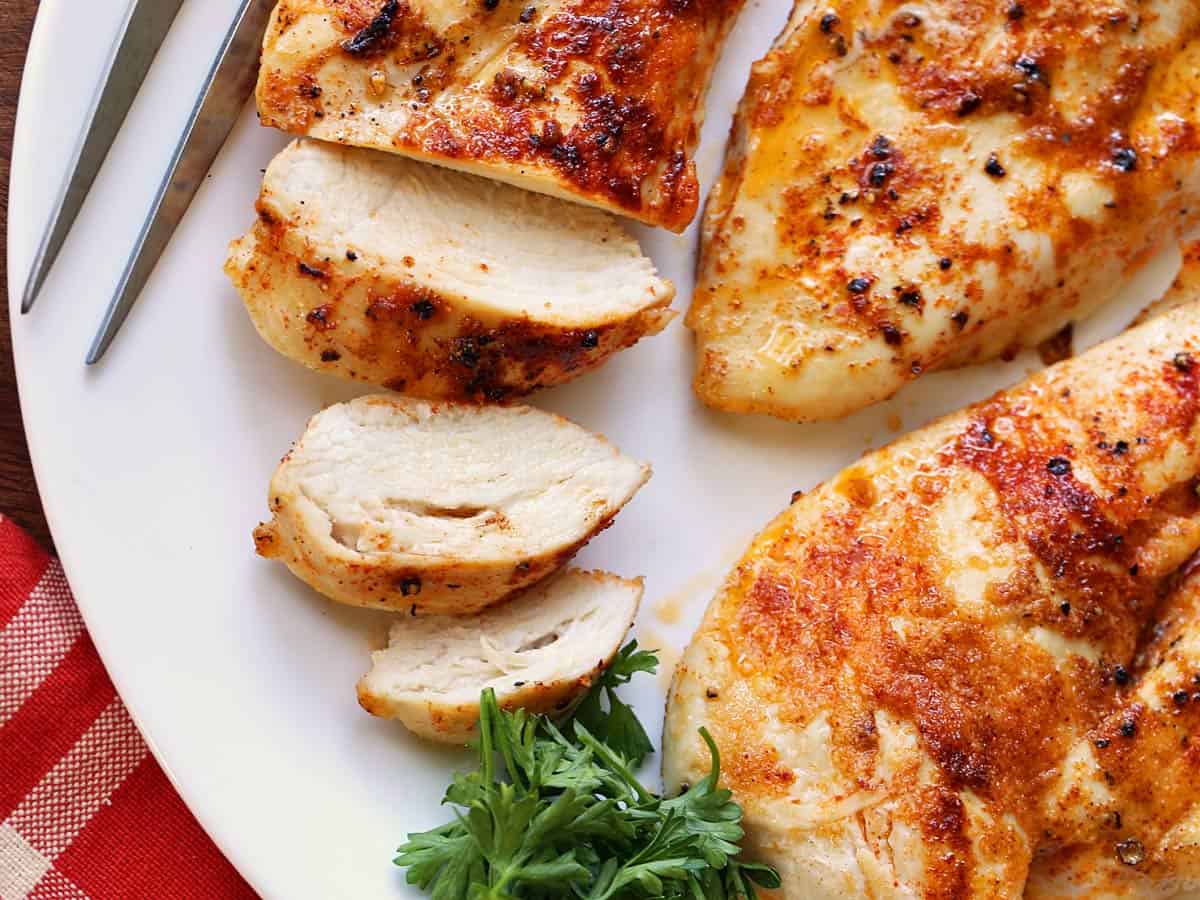 Sliced broiled chicken on a plate.