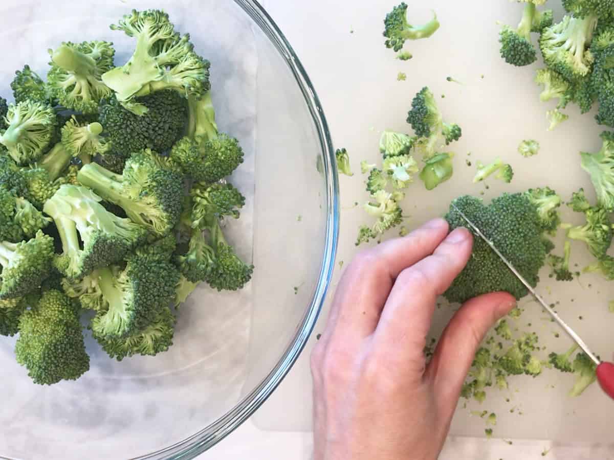 Cutting large broccoli florets into bite-sized pieces.