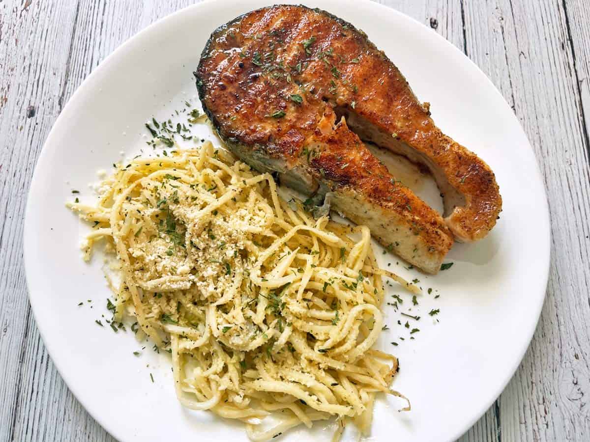 A grilled salmon steak is served with hearts of palm pasta.