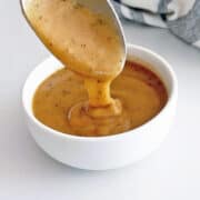 Homemade gravy is served in a white bowl.