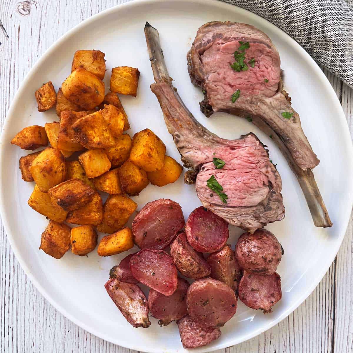 Roasted radishes are served as a side dish to lamb, alongside roasted pumpkin.