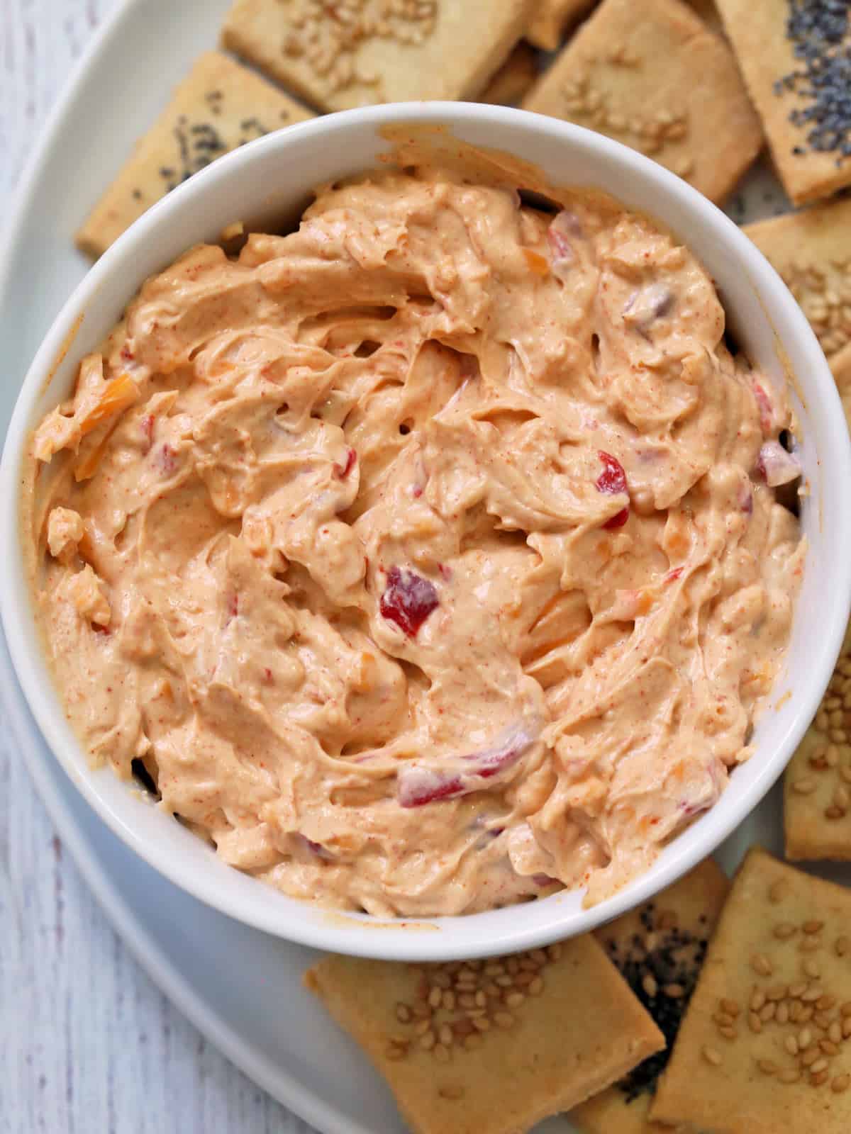 Pimento cheese is served in a bowl with crackers.