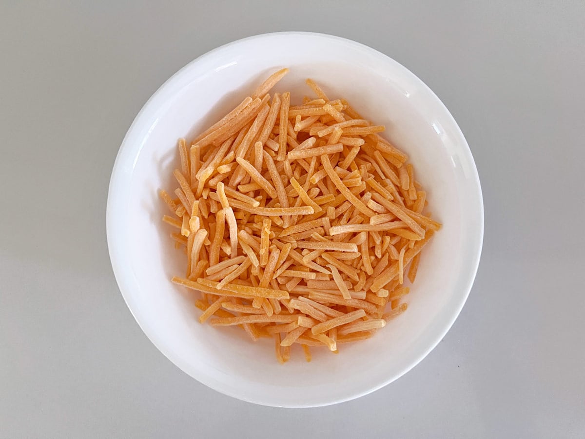 Coarsely shredded cheese in a bowl.