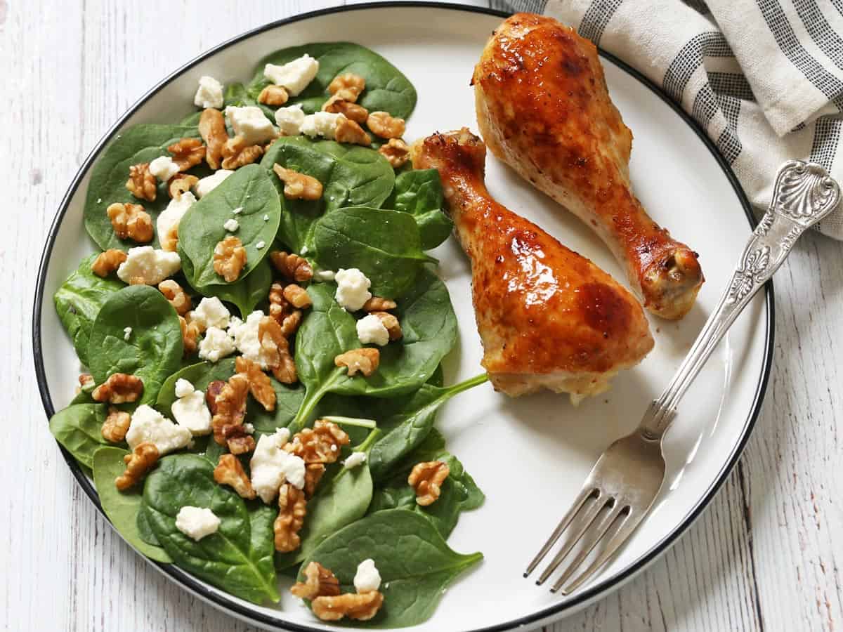Spinach salad is served with chicken.