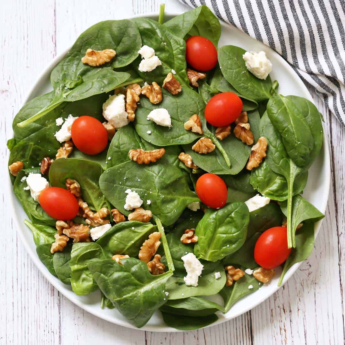 A spinach salad variation with feta, walnuts, and tomatoes.