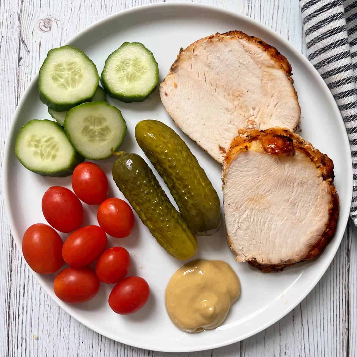 Turkey breast leftovers are served with mustard, veggies, and pickles.