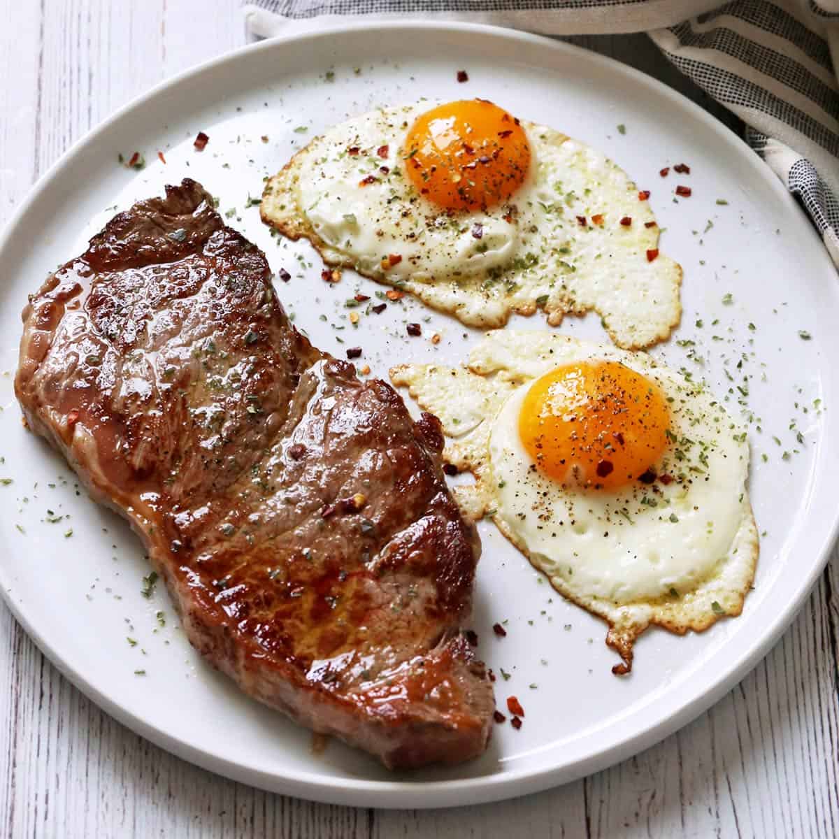 Crispy fried eggs are served with a steak.