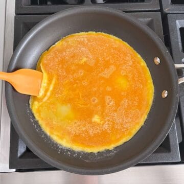 Lifting the edges of the omelette.