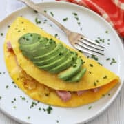 An omelette is topped with avocado.