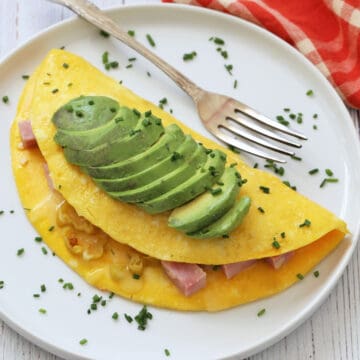 An omelette is topped with avocado.