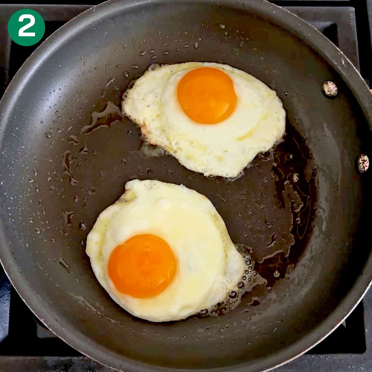 Two sunny side up eggs in a skillet.