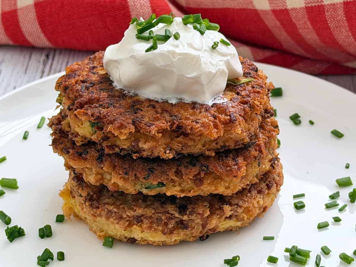 Cauliflower fritters are topped with sour cream.