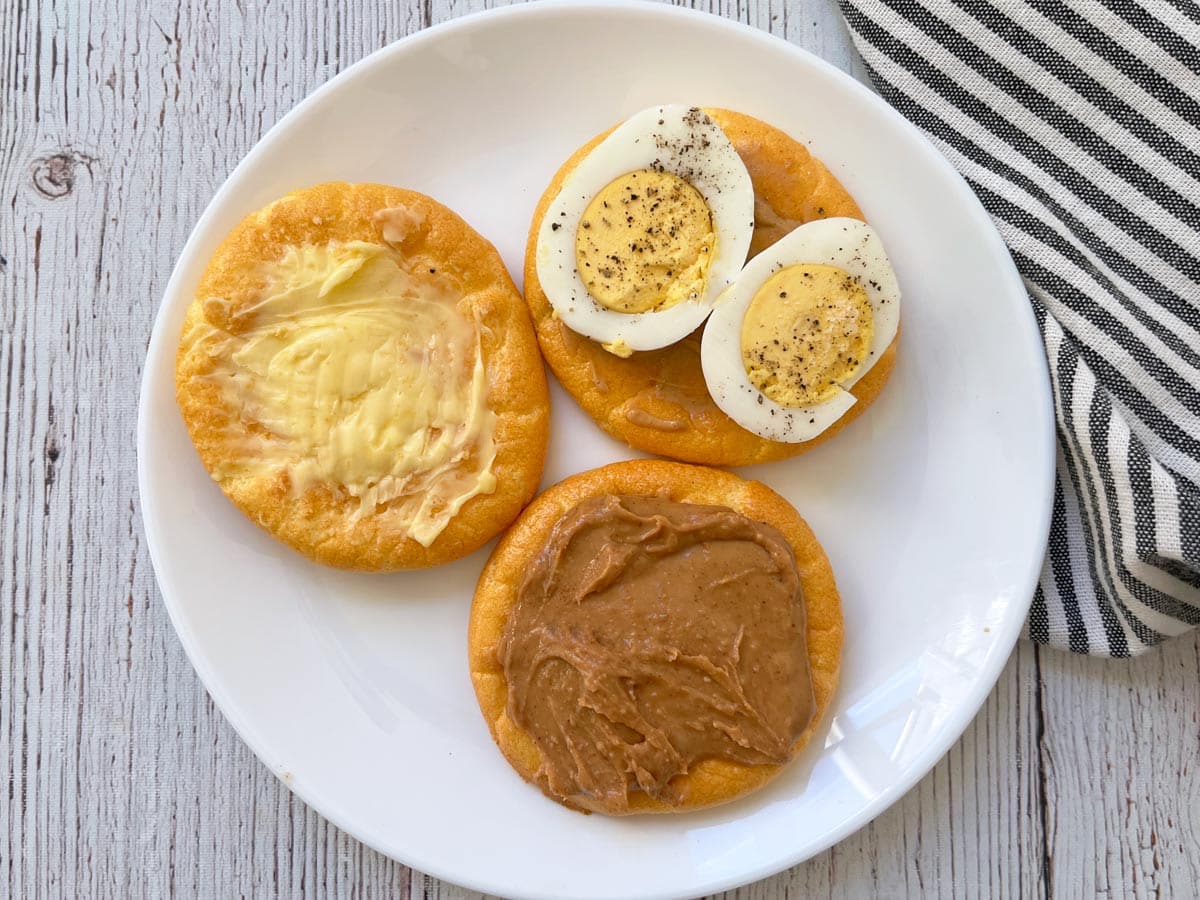 Cloud bread with three different toppings: butter, an egg, and peanut butter.