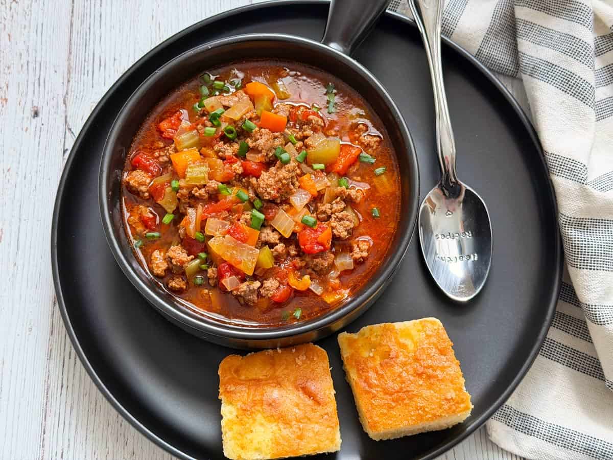 Hamburger soup is served with cornbread.