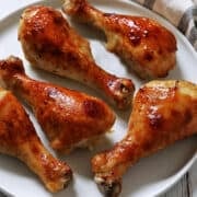 Honey garlic chicken is served on a white plate with a napkin.