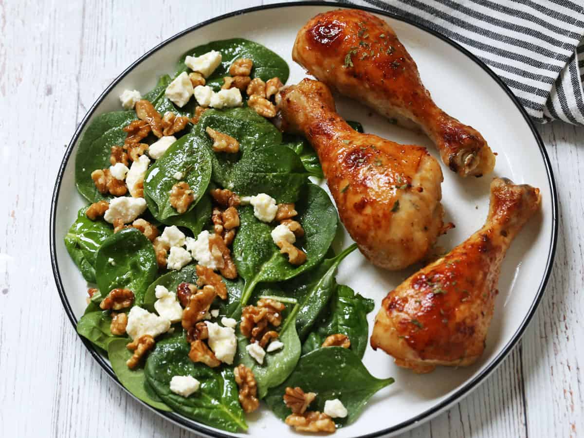 Honey garlic chicken leftovers are served with a side of spinach salad.