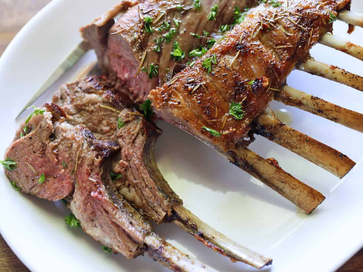 Rack of lamb on a white platter.